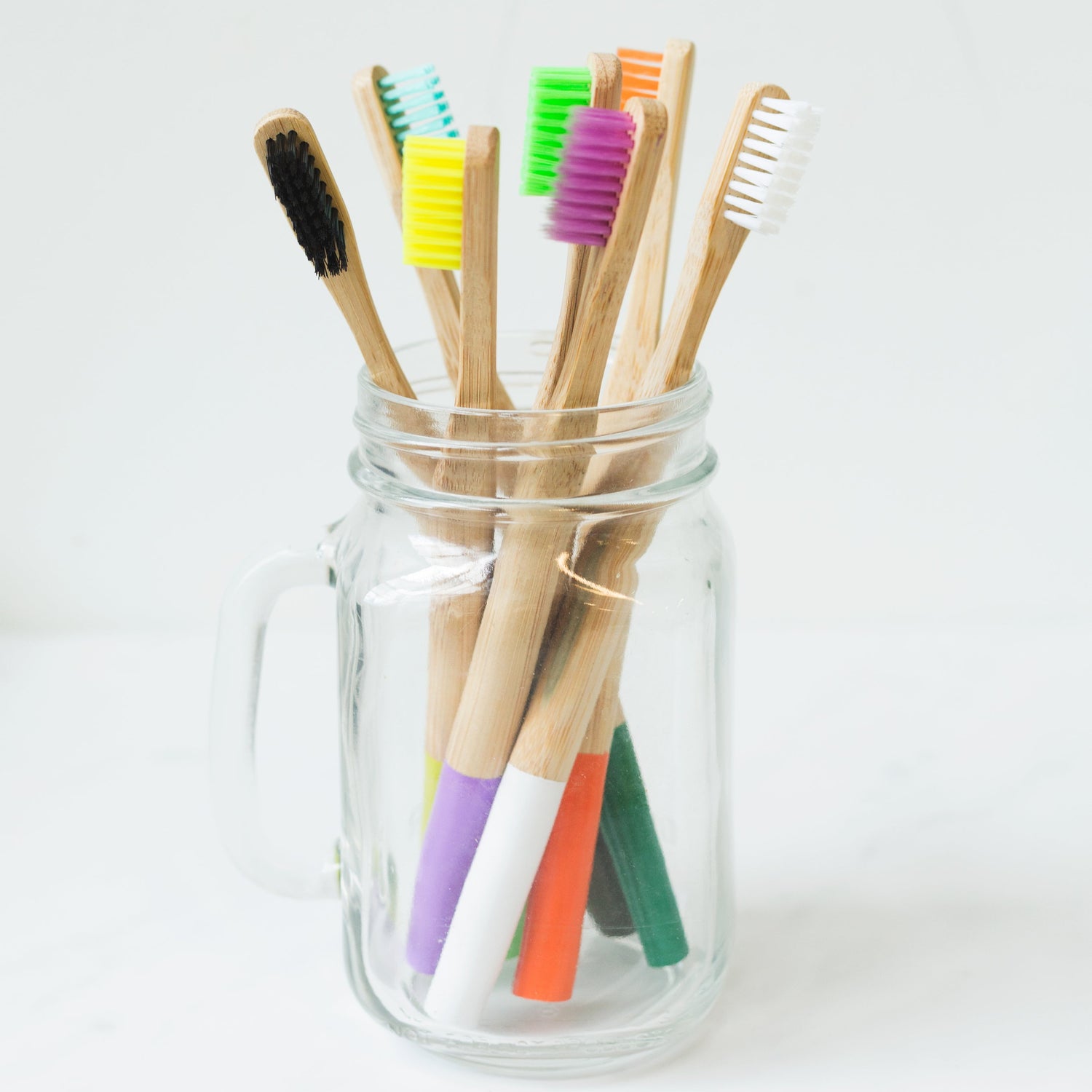 Multi-colored toothbrushes arranged in a glass, representing Grin & Glow’s vibrant and fresh approach to dental care and smile enhancement.