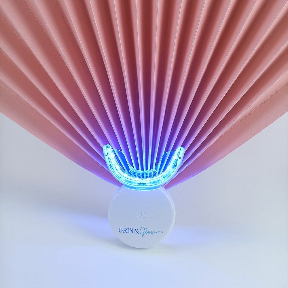 Grin & Glow Teeth Whitening Kit – vegan-friendly, non-invasive whitening system with LED light, whitening gel, and applicator for a brighter smile at home.