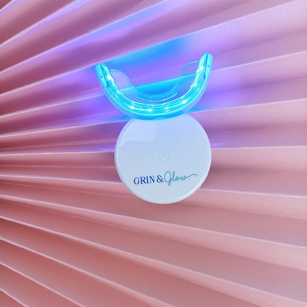 Grin & Glow Teeth Whitening Kit – vegan-friendly, non-invasive whitening system with LED light, whitening gel, and applicator for a brighter smile at home.